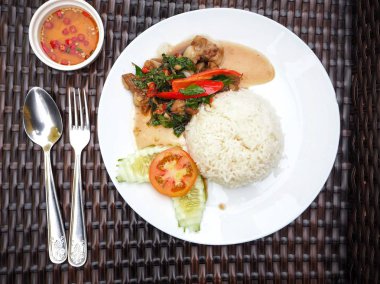 Beyaz tabakta Tay fesleğen domuz pirinç ve balık sosu ile