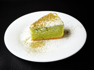 Taze yeşil çay pasta siyah arka plan üzerine beyaz plaka üzerinde