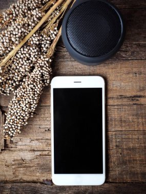 ahşap yüzey üzerinde bluetooth sözcü ve smartphone üstten görünüm