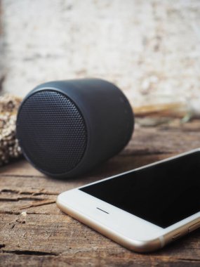 akıllı telefon ve bluetooth hoparlör rustik ahşap masanın üzerinde yatan yakın çekim çekim
