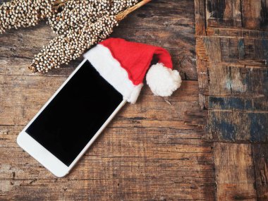 boş ekran ve Noel şapka ile smartphone ahşap masa üzerinde görmek