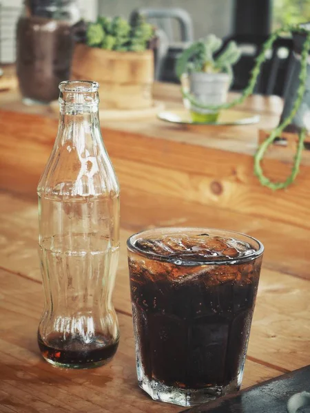 Buz Küplerinde Cam Ahşap Masa Üzerinde Boş Şişe Soda Içmek — Stok fotoğraf