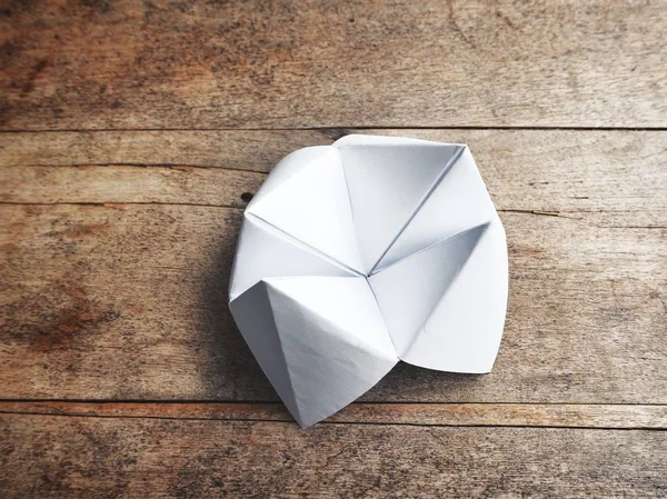 Paper fortune teller on wooden table