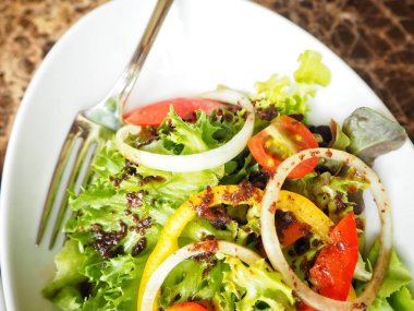 Beyaz tabakta taze sebze salatası görünümü Kapat