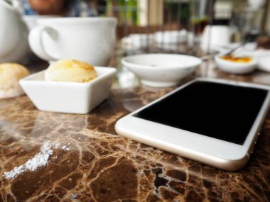 Çörekler ve İngilizce çay ile akıllı telefon