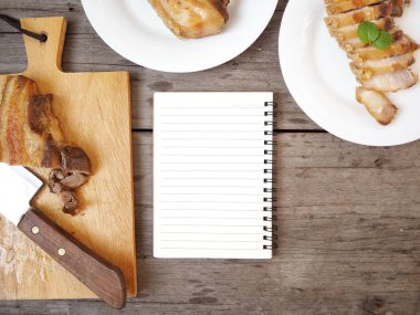 ızgara domuz eti üstten görünüm kesme tahtası ve mutfak masa üstünde defter