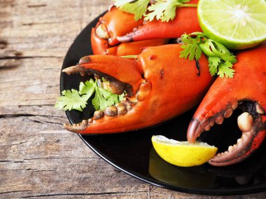 Kireç veya limon ahşap arka plan üzerinde ile servis haşlanmış yengeç pençeleri