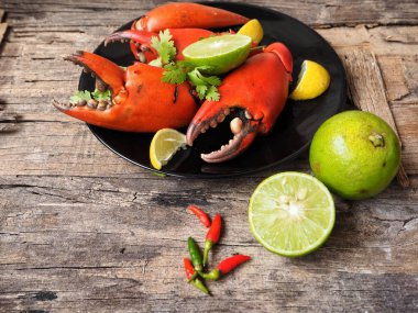 Kireç veya limon ahşap arka plan üzerinde ile servis haşlanmış yengeç pençeleri