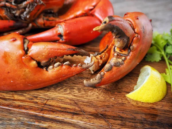 Kireç veya limon ahşap arka plan üzerinde ile servis haşlanmış yengeç pençeleri