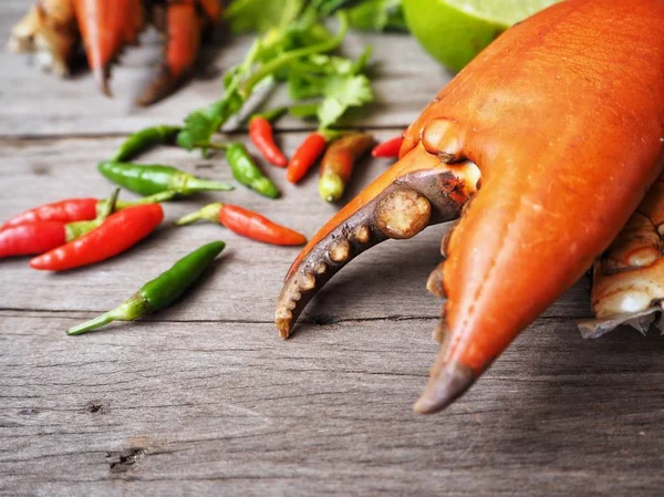 Ahşap arka plan üzerinde pişmiş yengeç pençeleri baharatlı biber ile görünümü Kapat