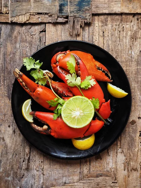 Kireç veya limon ahşap arka plan üzerinde ile servis haşlanmış yengeç pençeleri