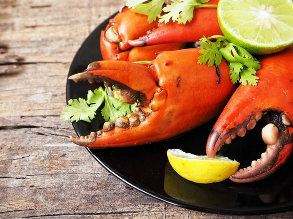 Kireç veya limon ahşap arka plan üzerinde ile servis haşlanmış yengeç pençeleri