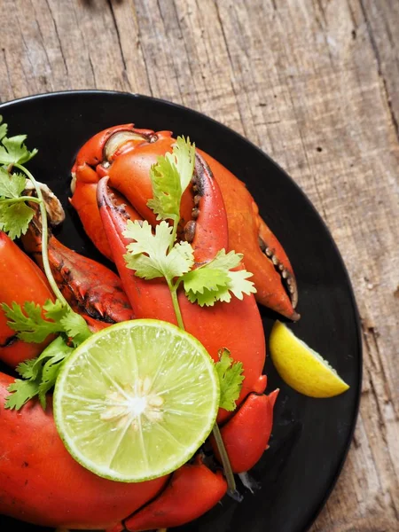 Kireç veya limon ahşap arka plan üzerinde ile servis haşlanmış yengeç pençeleri