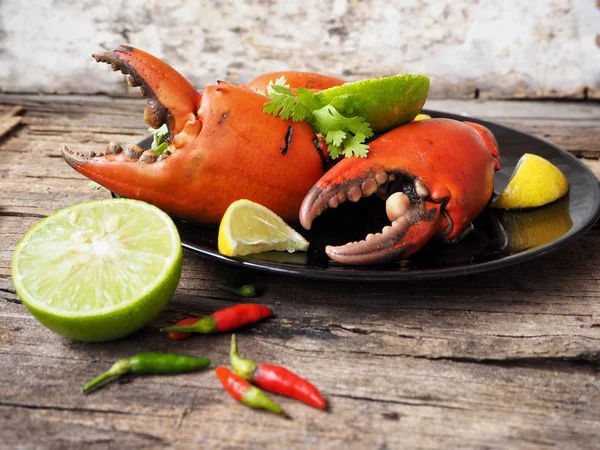 Kireç veya limon ahşap arka plan üzerinde ile servis haşlanmış yengeç pençeleri