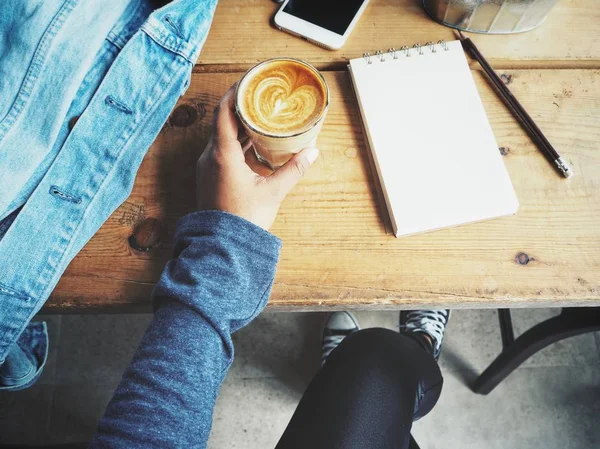 Nő üres jegyzettömböt és irodai asztal a csésze kávé — Stock Fotó