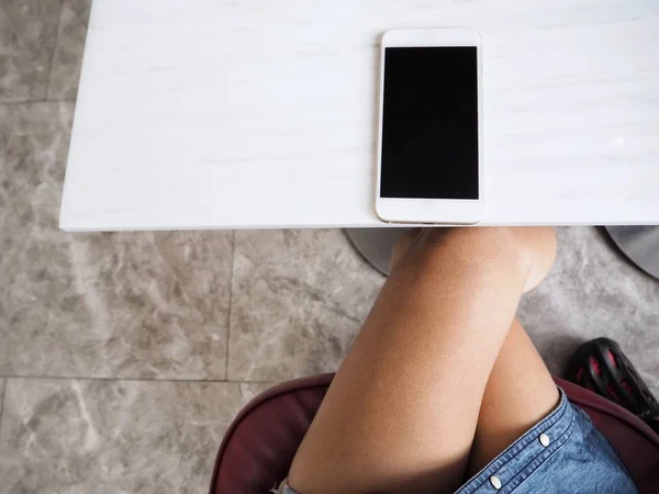 Legs of woman with smart phone — Stock Photo, Image