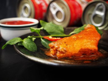 soslu lezzetli konserve balık plaka ve arkasında kapalı kutular görmek