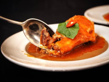 konserve balık sosu ve beyaz tabak kaşık ile siyah görmek