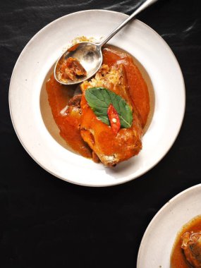 konserve balık sosu ve beyaz tabak kaşık ile üstten görünüm siyah