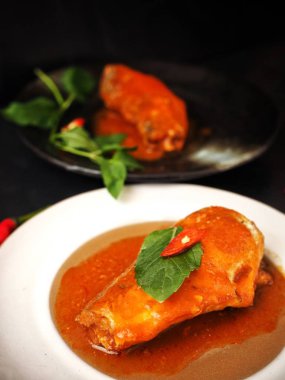 Siyah zemin üzerine kırmızı biber ile konserve balık