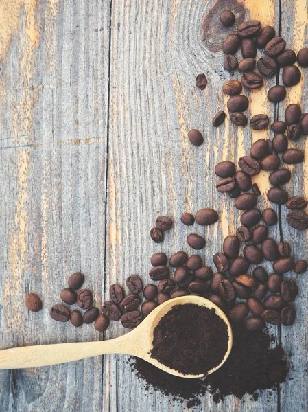 木製卓上型にスプーンで豆の焙煎コーヒーの粉の上から見る — ストック写真