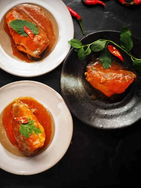 Siyah zemin üzerine kırmızı biber ile konserve balık