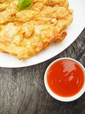 Pilav kızarmış yumurta ve ahşap arka plan üzerinde sriracha biber sosu ile