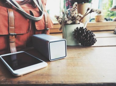Bluetooth hoparlör smartphone ve çanta ile bakış ahşap masa üzerinde kapatın