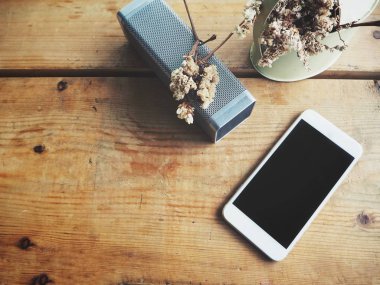 akıllı telefon ve bluetooth hoparlör ile kurutulmuş bitki tencerede ahşap masanın üzerinde yatan bir üstten görünüm