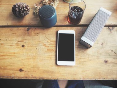 bluetooth hoparlör smartphone ve soda içkiyle üstten görünüm ahşap tablo