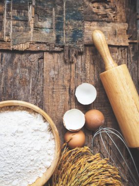 Ahşap arka plan üzerinde yumurta un oklava ve çırpma teli ile pişirme