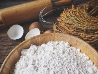 Ahşap arka plan üzerinde yumurta un oklava ve çırpma teli ile pişirme