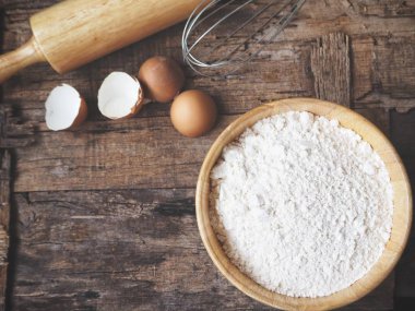 Ahşap arka plan üzerinde yumurta un oklava ve çırpma teli ile pişirme