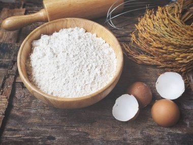 Ahşap arka plan üzerinde yumurta un oklava ve çırpma teli ile pişirme