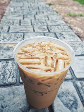 plastik kap taş döşeme üzerinde lezzetli buzlu kahve yakın çekim vurdu