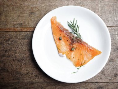 ahşap masa üzerinde plaka üzerinde lezzetli füme somon üstten görünüm