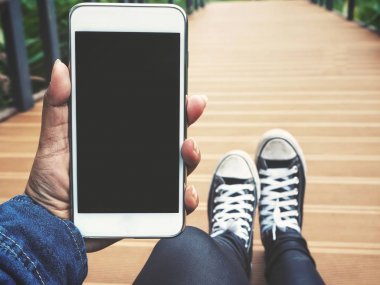 Beyaz smartphone tutan kadın görünümü Kapat