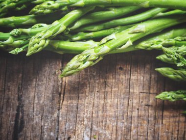 Ahşap arka planda taze yeşil kuşkonmaz