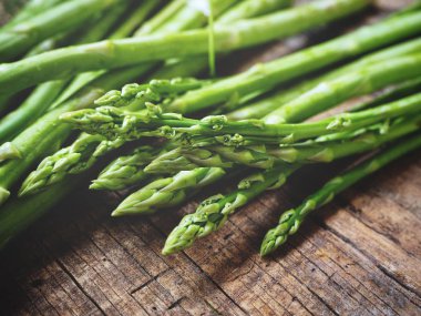 Ahşap arka planda taze yeşil kuşkonmaz