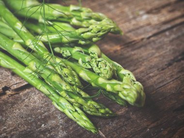 Ahşap arka planda taze yeşil kuşkonmaz