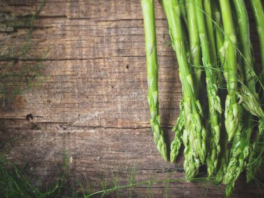 Ahşap arka planda taze yeşil kuşkonmaz