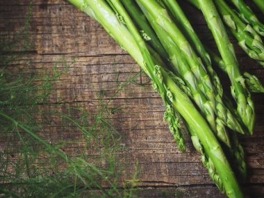 Ahşap arka planda taze yeşil kuşkonmaz