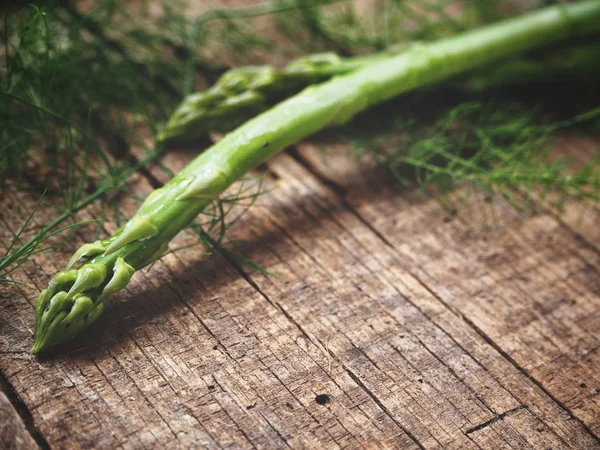 Ahşap arka planda taze yeşil kuşkonmaz