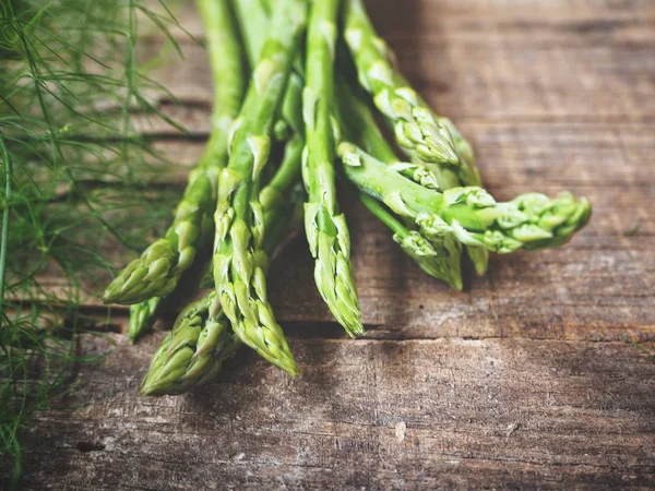 Ahşap arka planda taze yeşil kuşkonmaz