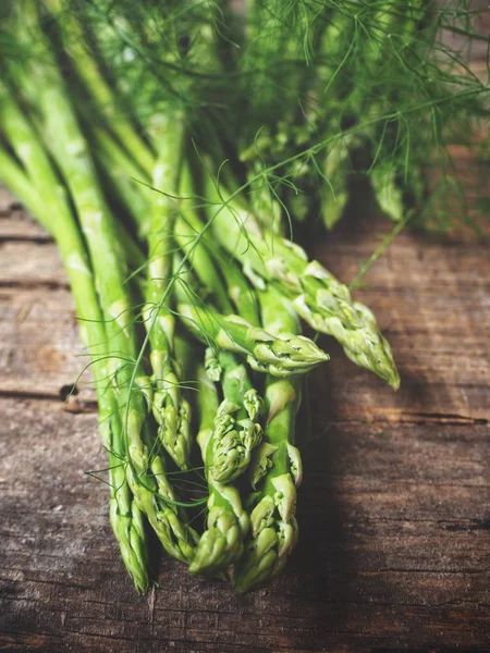 Ahşap arka planda taze yeşil kuşkonmaz