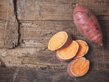 Eski ahşap zemin üzerine taze çiğ tatlı patates