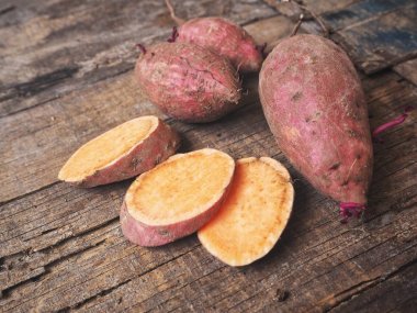 Eski ahşap zemin üzerine taze çiğ tatlı patates