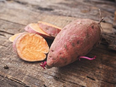 Eski ahşap zemin üzerine taze çiğ tatlı patates