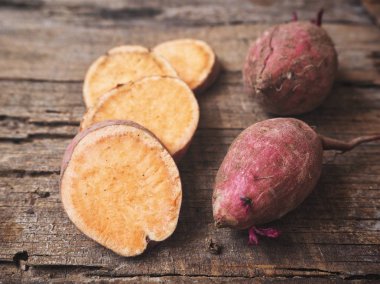 Eski ahşap zemin üzerine taze çiğ tatlı patates