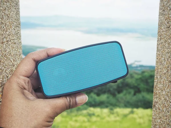 bluetooth hoparlör açık havada tutan kadın görüntüsünü kırpılmış